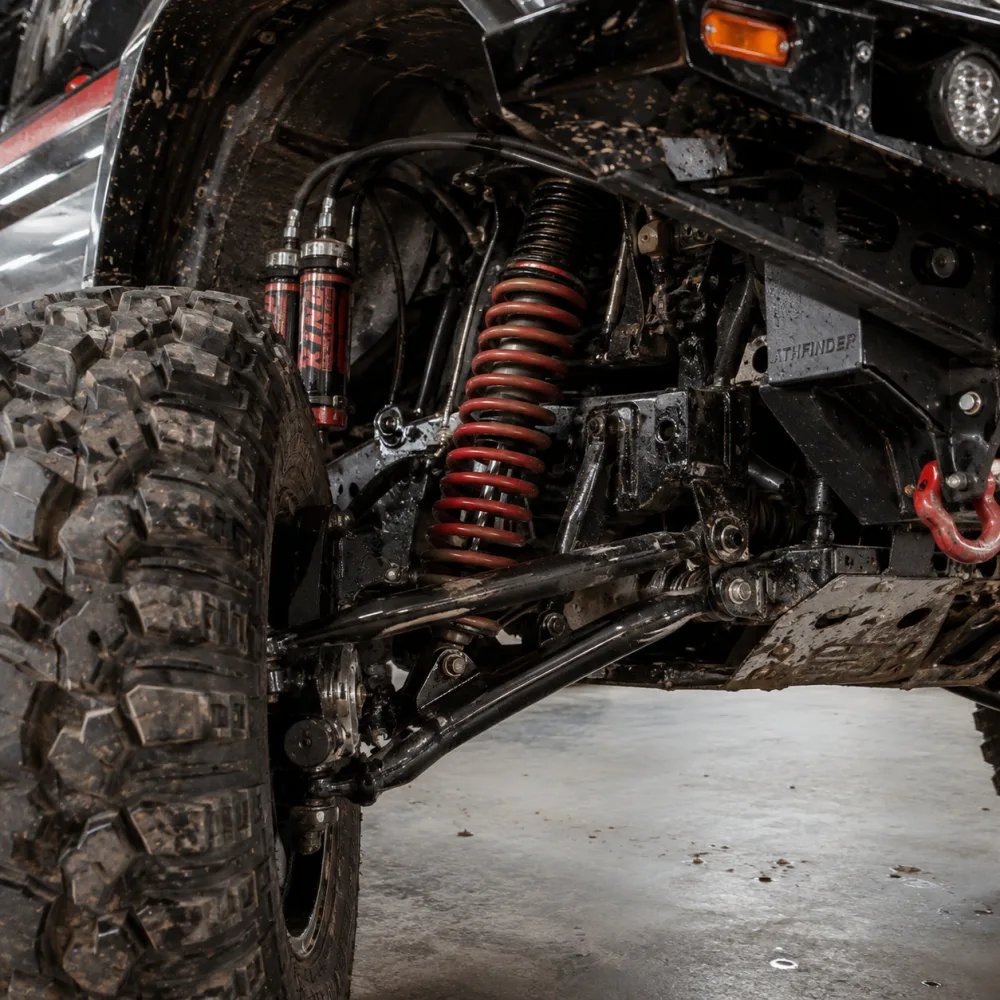 Close-up of the ATHFINDER red coil spring and heavy-duty off-road suspension