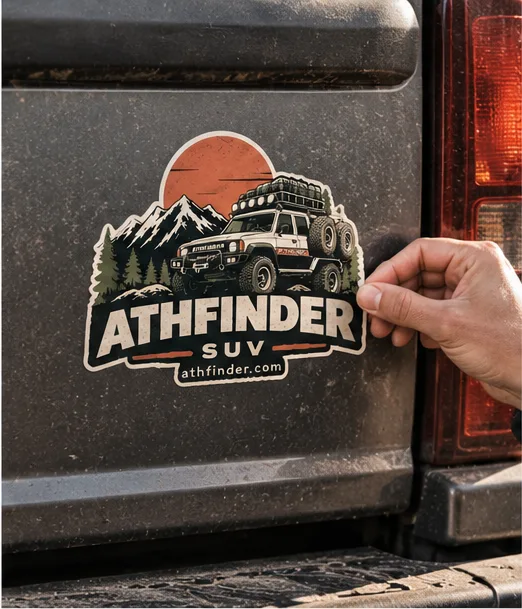 Hand applying the ATHFINDER SUV sticker to a dusty tailgate